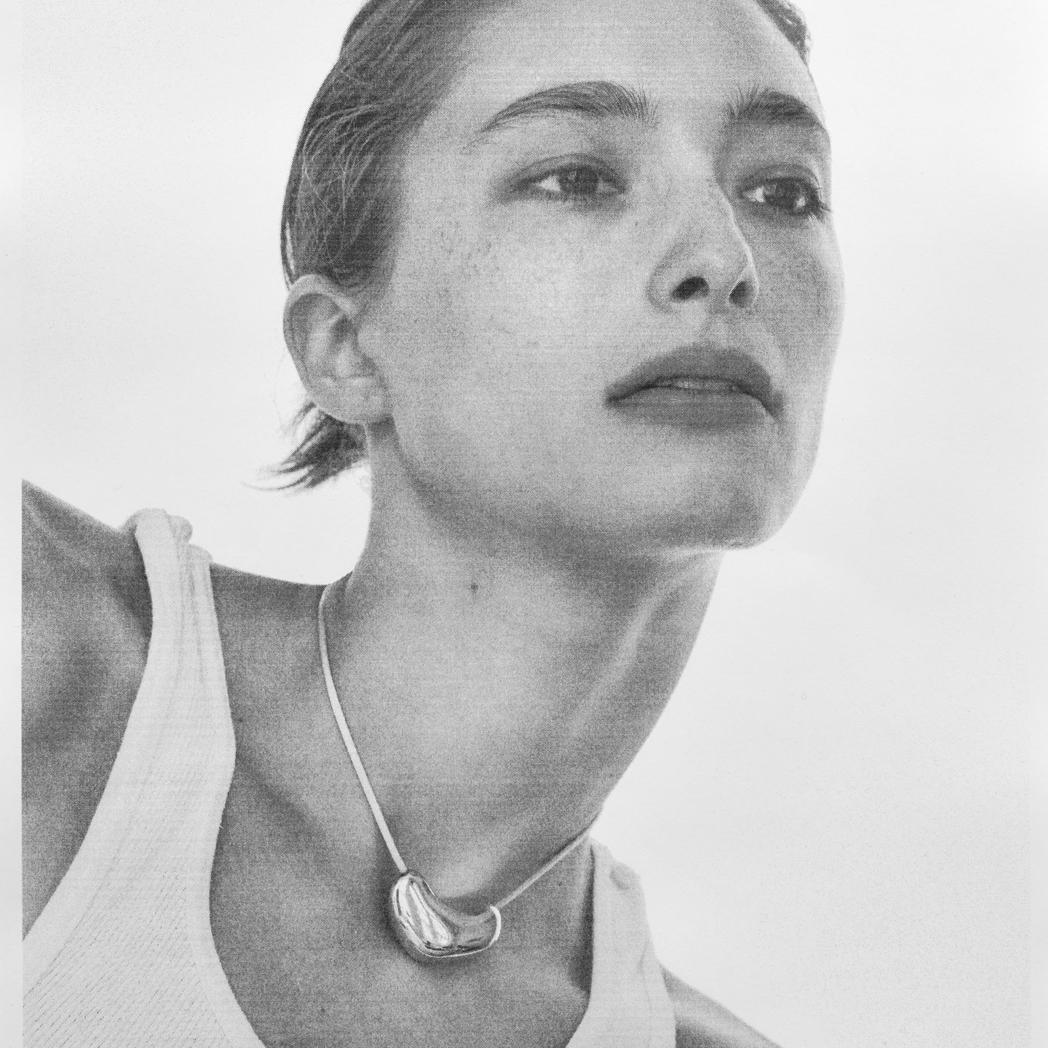 Woman wearing AGMES .925 Sterling Silver Sculpted Heart Pendant on Ivory Satin Cord. 